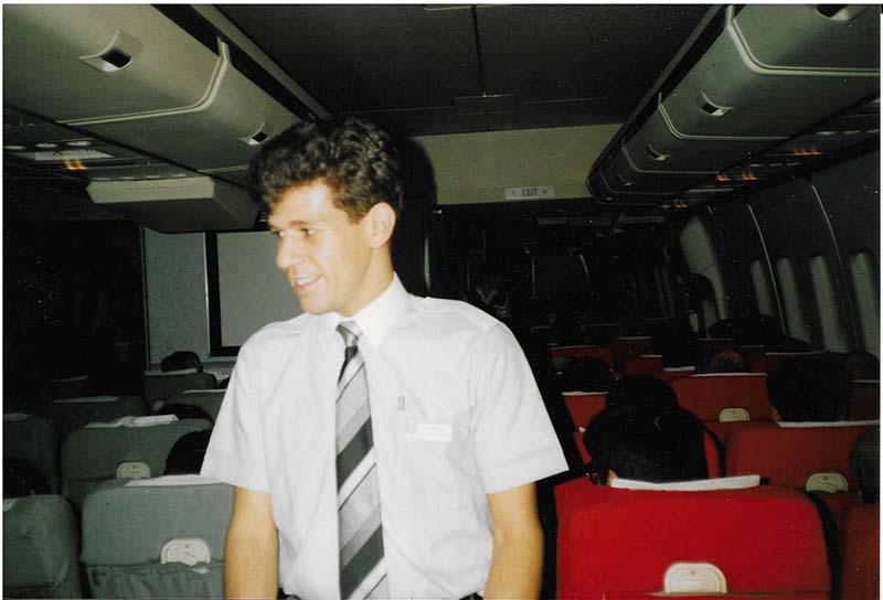 young male flight attendant in the aircraft cabin