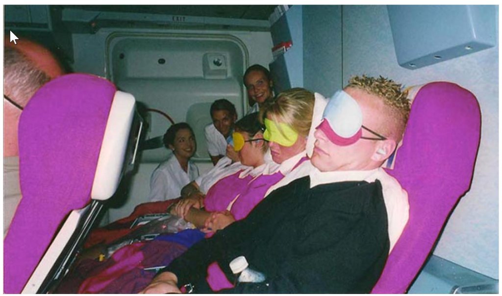 cabin crew sleeping during their rest break in passenger seats on the aircraft.  
